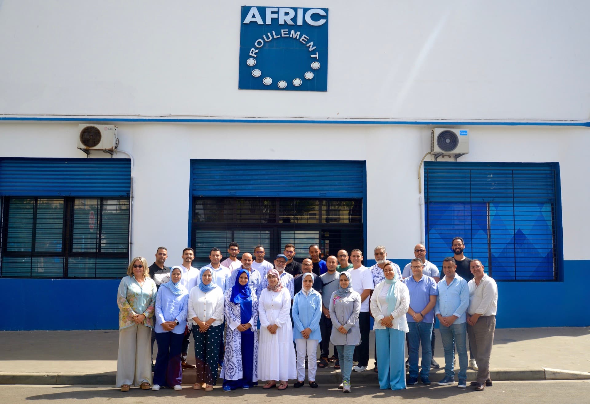 Équipe Afric Roulement devant le bâtiment